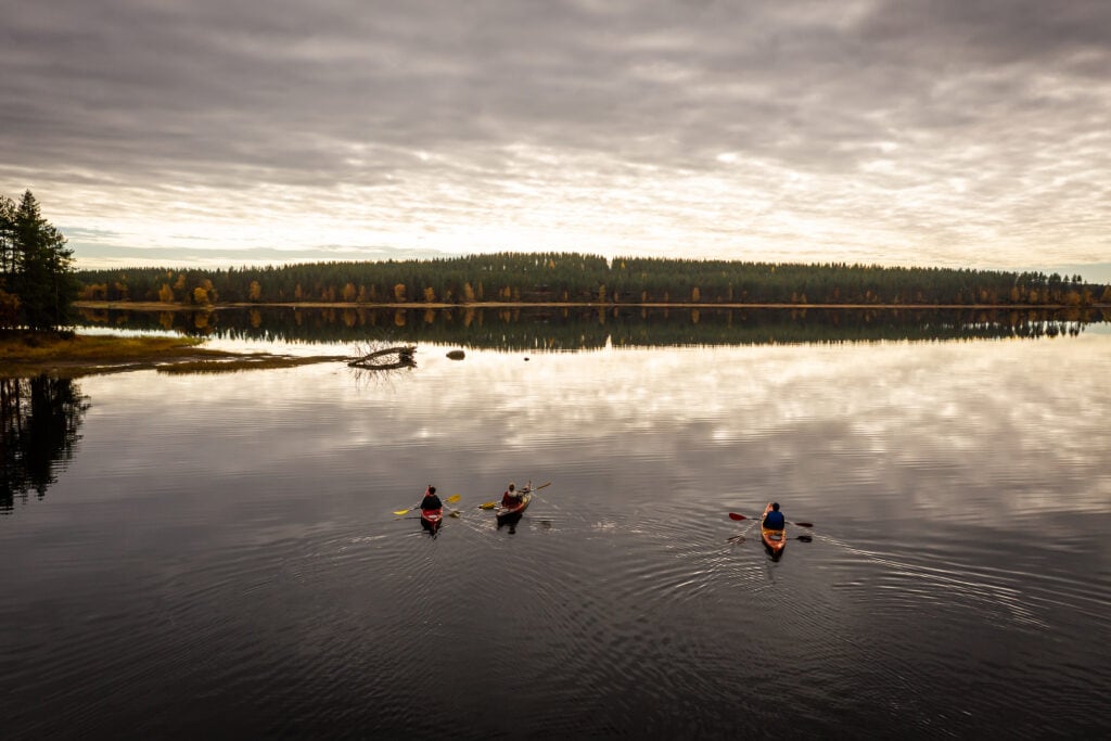 Iltahämärässä melojia järvellä