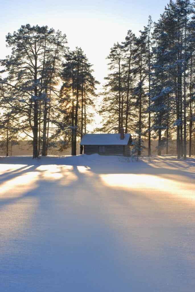 Saunamökki keskellä lumista maisemaa