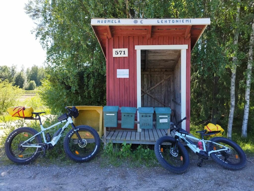 Vanha maitolaituri ja postilaatikoihin nojaavat sähköpyörät