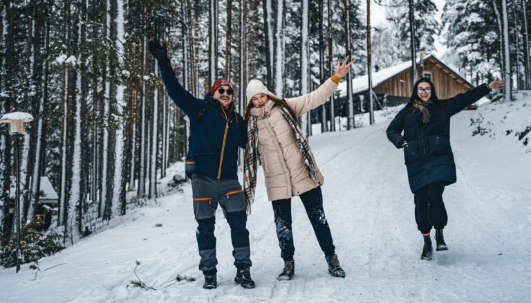 Ruunaan Matkailun pihalla kolme ihmistä